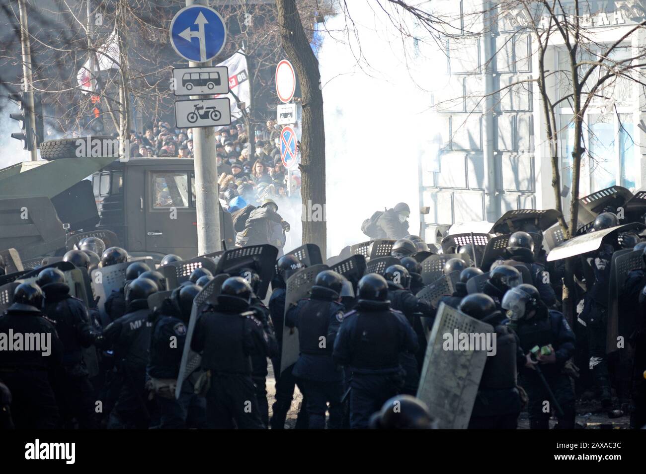 Des policiers armés de boucliers, des fusils de chasse à l'action de la pompe attaquent le barrage routier des manifestants. Révolution De La Dignité, rue Shelkovichnaya. 18.02.2014, Kiev, Ukrane Banque D'Images