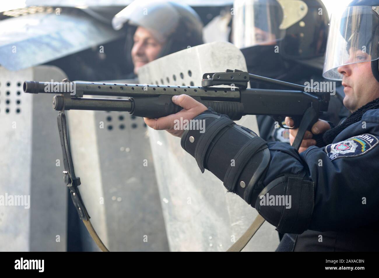 Des policiers armés de boucliers, des fusils de chasse à l'action de la pompe attaquent le barrage routier des manifestants. Révolution De La Dignité, rue Shelkovichnaya. 18.02.2014, Kiev, Ukrane Banque D'Images