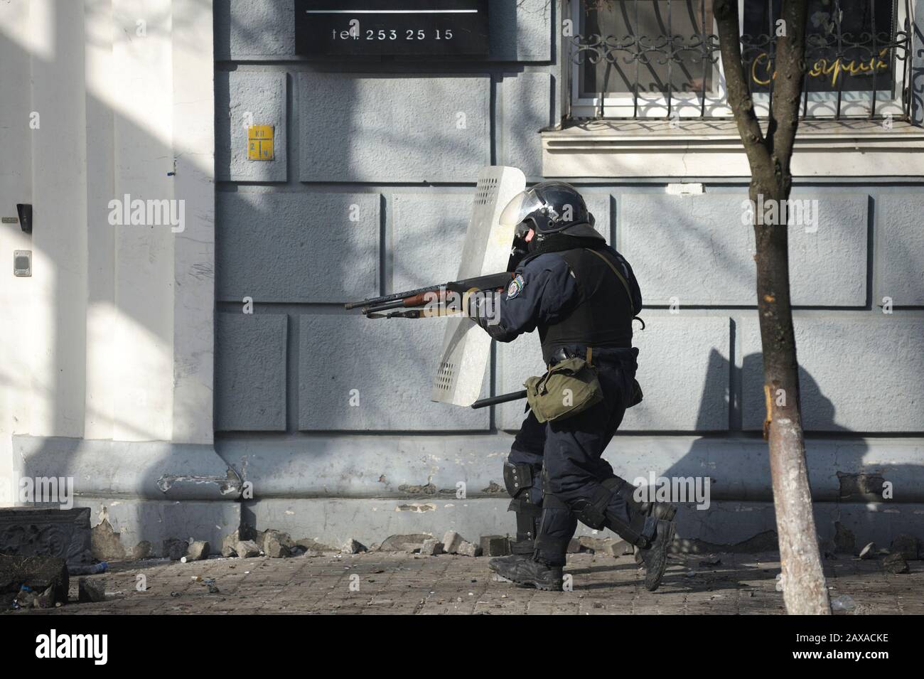 Des policiers armés de boucliers, des fusils de chasse à l'action de la pompe attaquent le barrage routier des manifestants. Révolution De La Dignité, rue Shelkovichnaya. 18.02.2014, Kiev, Ukrane Banque D'Images