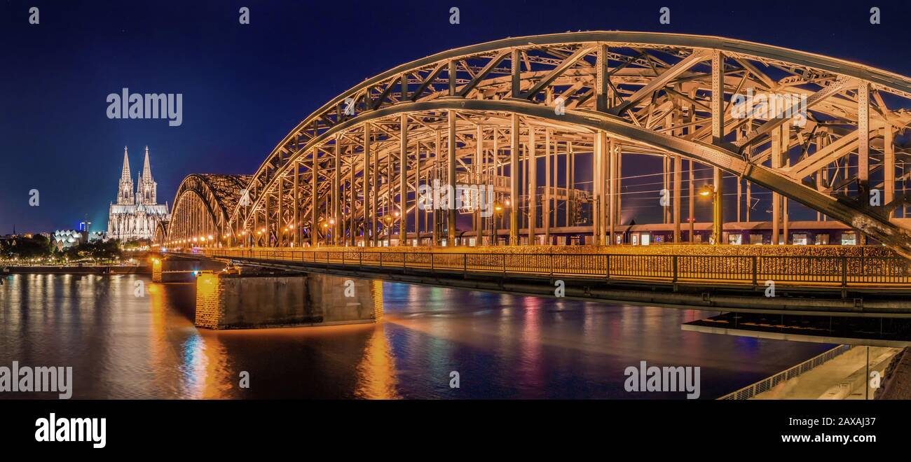 Panorama nocturne du pont lumineux Hohenzollern sur le Rhin. Magnifique paysage urbain de Cologne, Allemagne avec cathédrale et Grand Saint-Martin C Banque D'Images