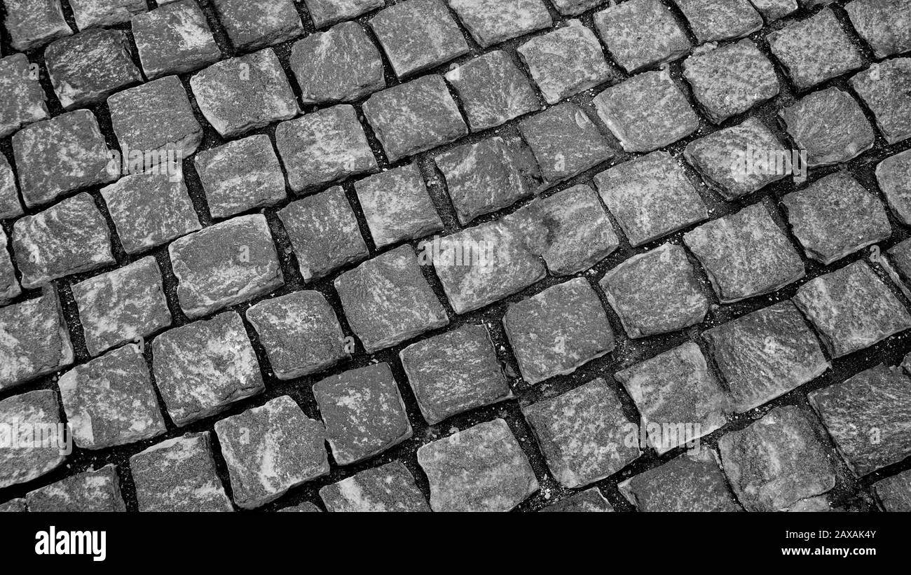 Granite pavé pavé de pierre cubique gros plan de la texture de l'arrière-plan. Fond d'écran ou texture de la chaussée. Photographie noir et blanc Banque D'Images