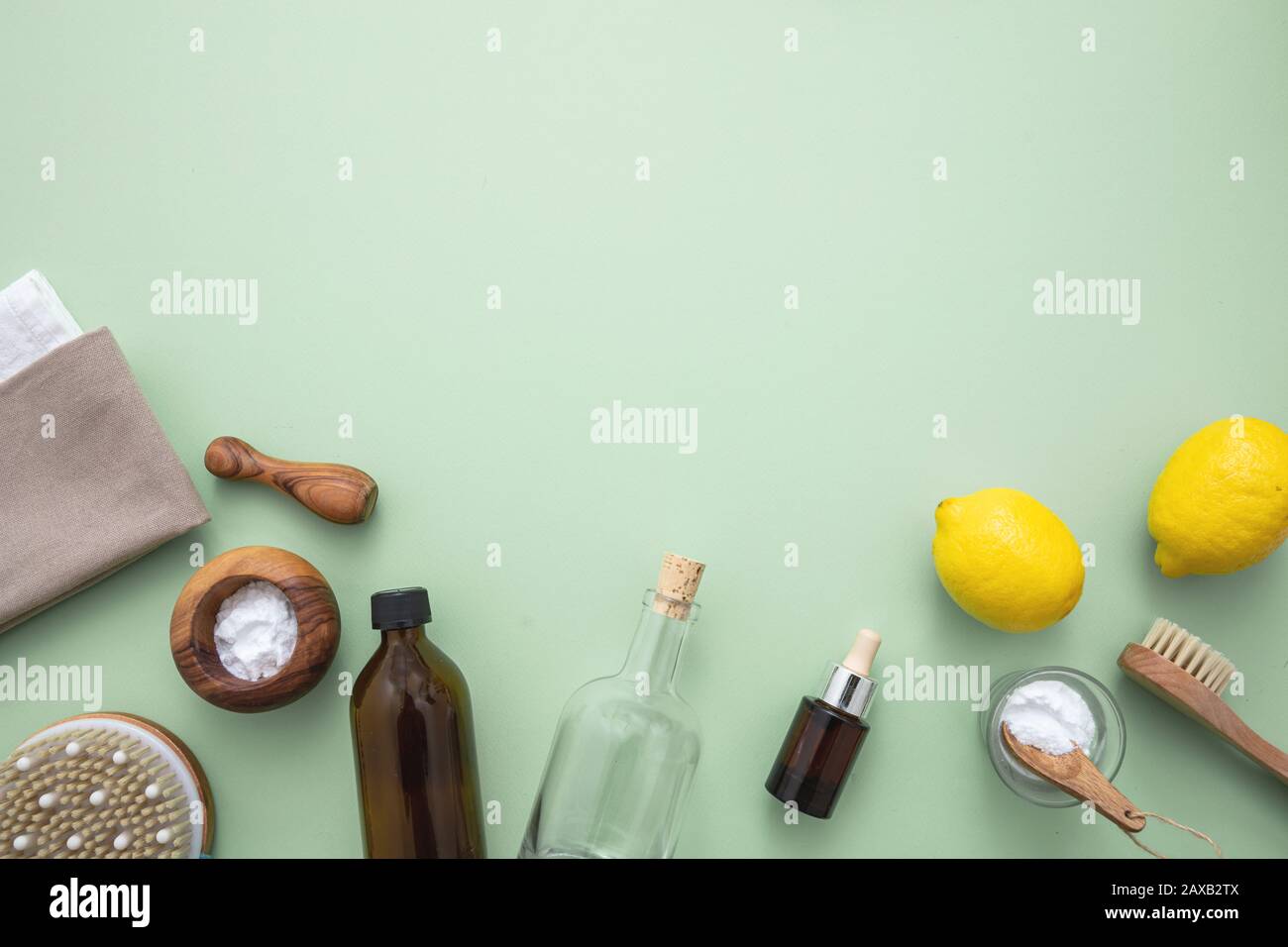 Environnement de ménage éco-nettoyant. Produits de nettoyage faits maison non toxique plat, bicarbonate de soude, vinaigre de citron et fleurs fraîches sur la couleur verte ba Banque D'Images