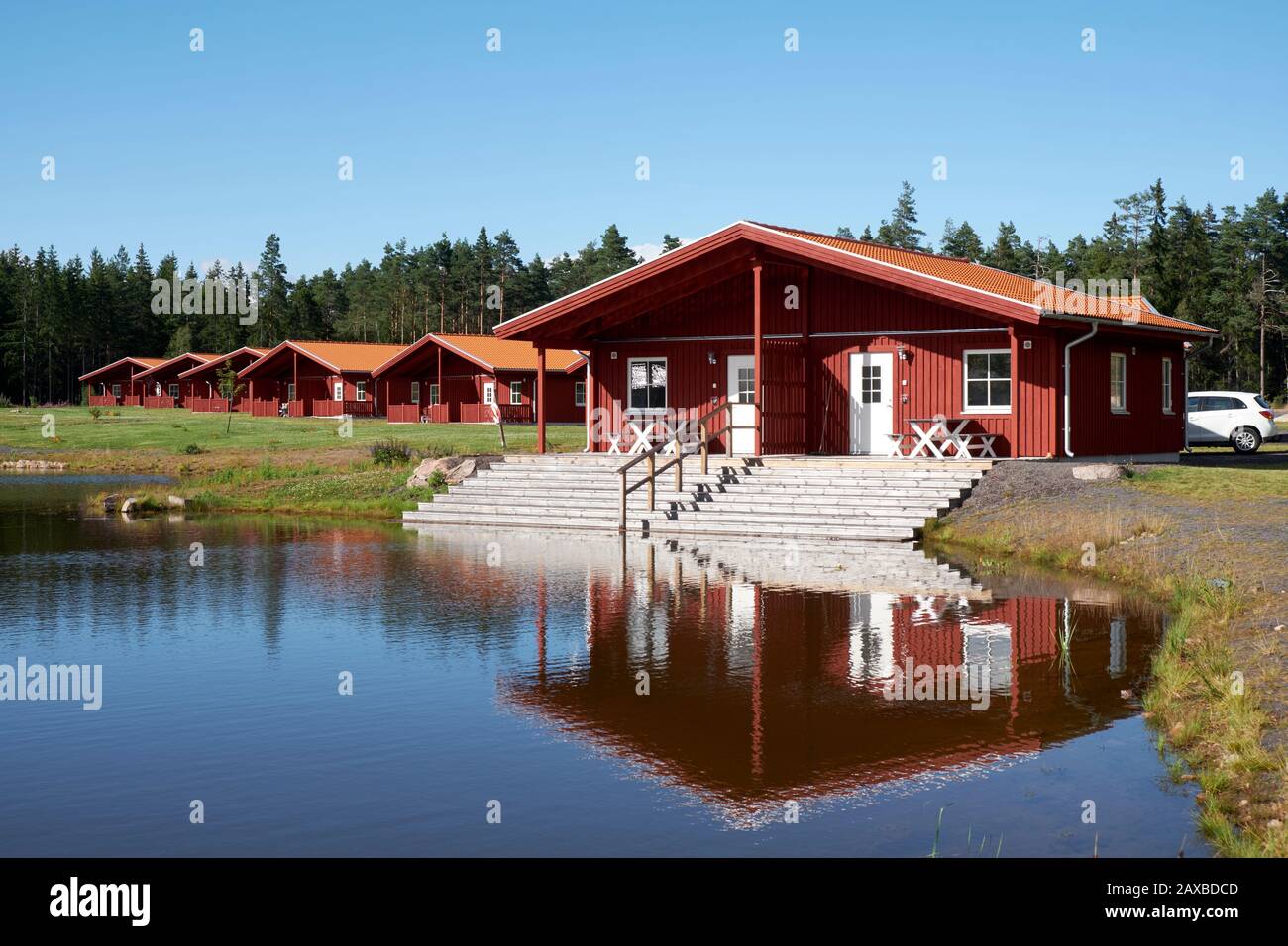 Chalets de vacances en bois peints en rouge au bord du lac au Kosta Lodge Banque D'Images