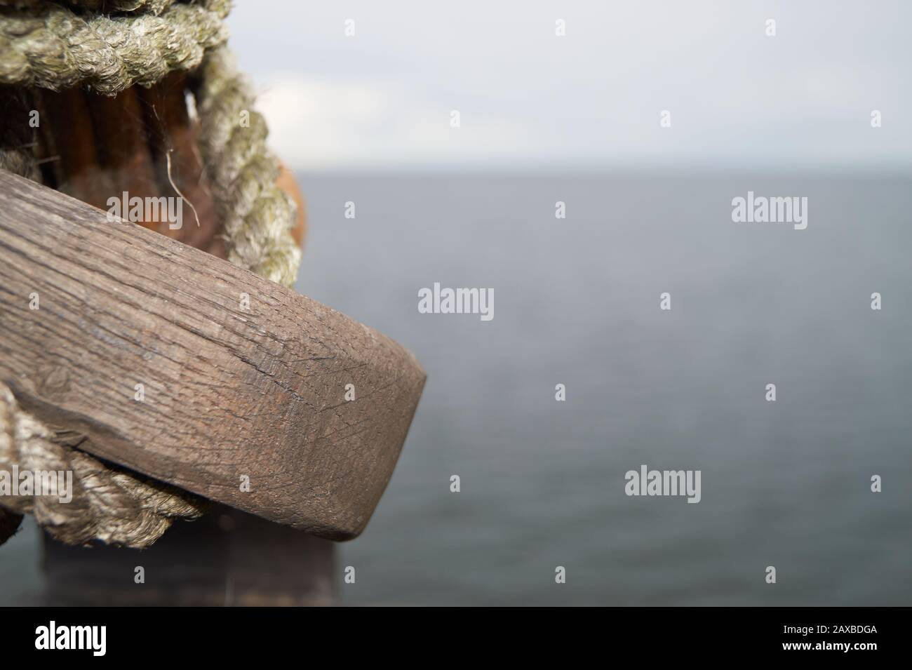 Vieux anneau en bois sur un poteau en bois avec la mer en arrière-plan Banque D'Images