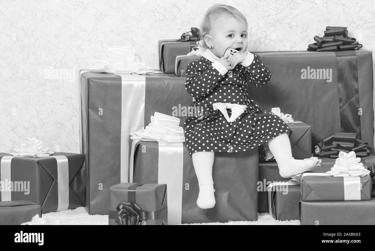 Vacances en famille. Petite fille jouer près de pile de boîtes cadeaux. Cadeaux pour enfant premier noël. Fêtez le premier noël. Cadeaux de Noël pour tout-petit. Bébé premier noël une fois dans l'événement à vie. Banque D'Images