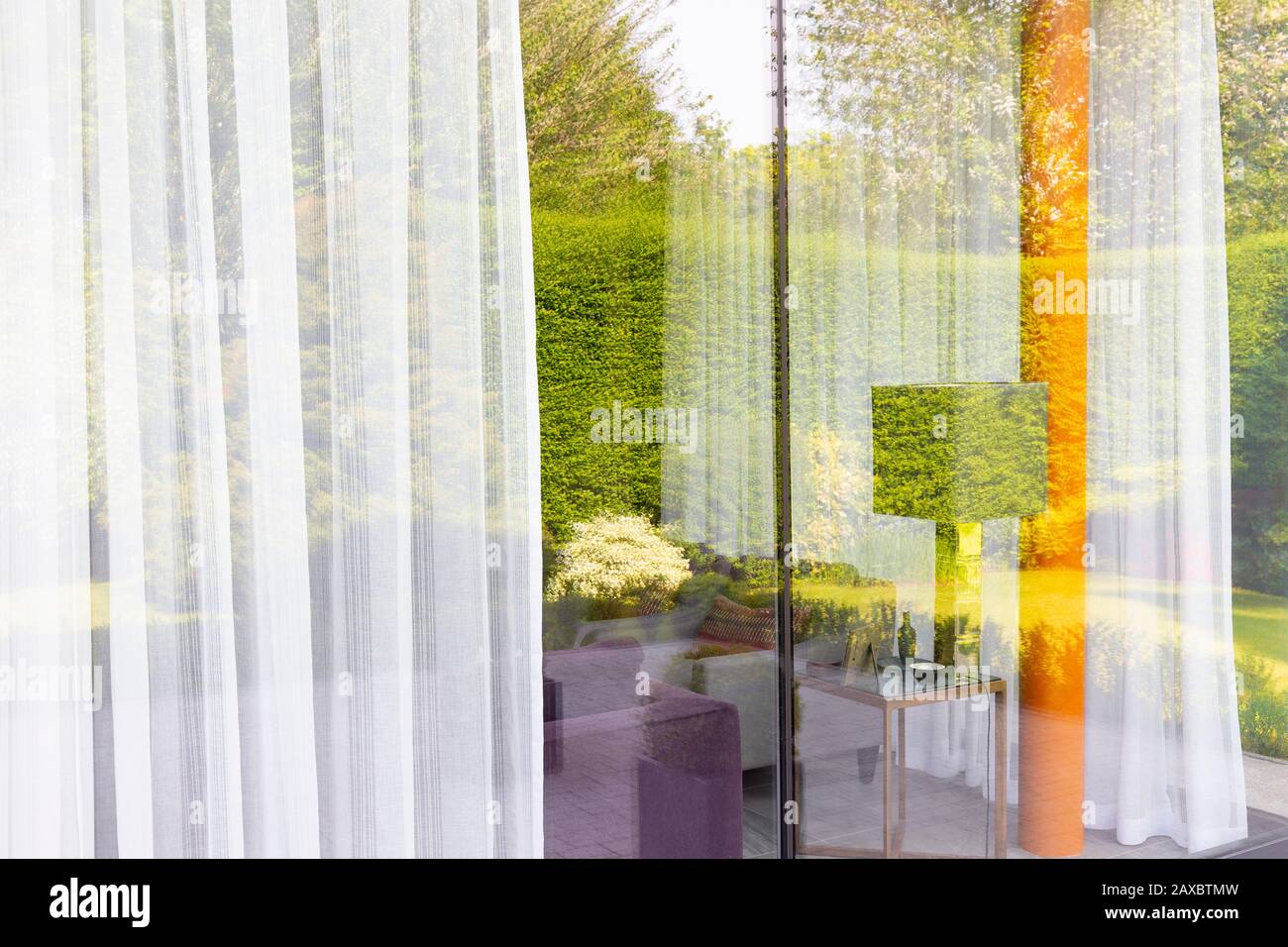 Réflexion sur le jardin sur les fenêtres modernes du salon au plafond Banque D'Images