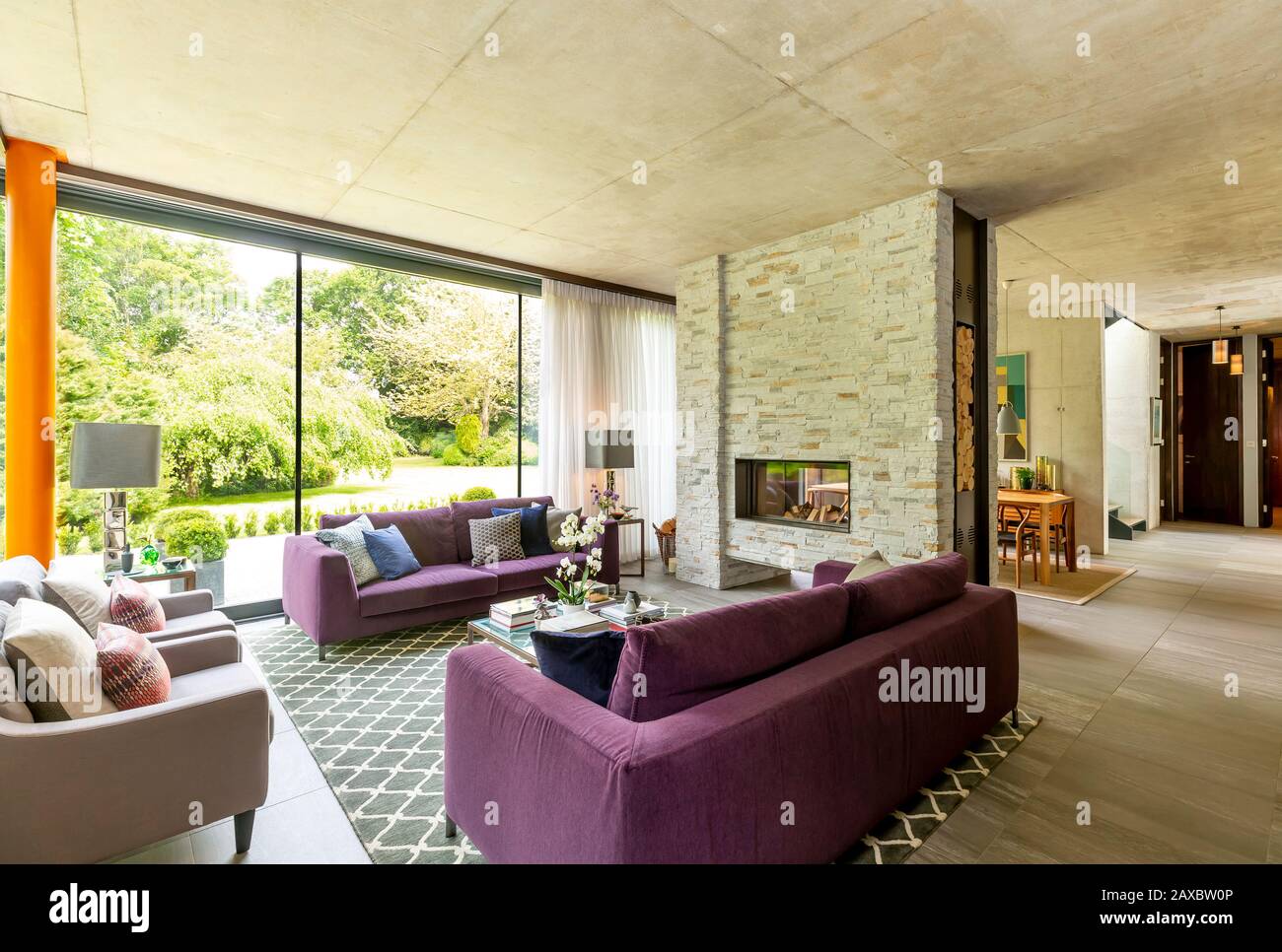 Salon moderne avec cheminée en briques et vue sur le jardin Banque D'Images
