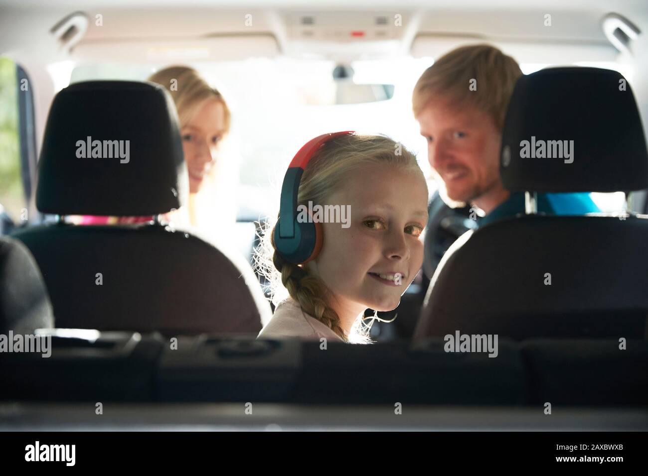 Portrait fille souriante avec casque à cheval dans le siège arrière de la voiture Banque D'Images