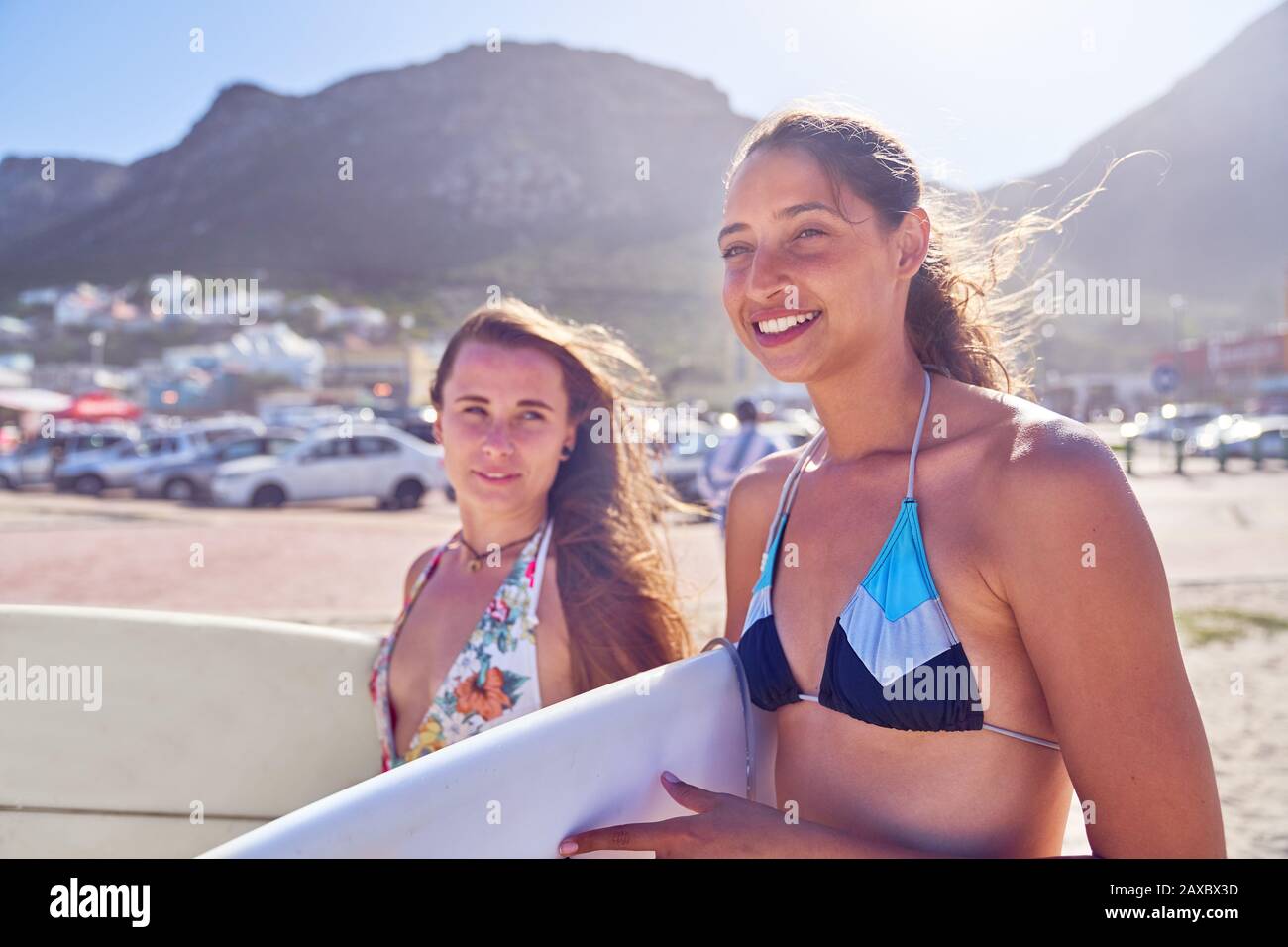 Jeunes surfeurs féminins avec planches de surf sur la plage ensoleillée Banque D'Images