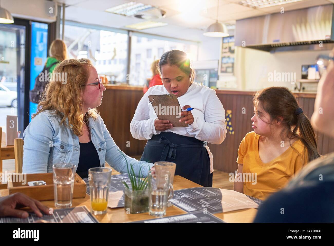 Jeune femme serveur avec Syndrome De Down prenant la commande de client Banque D'Images