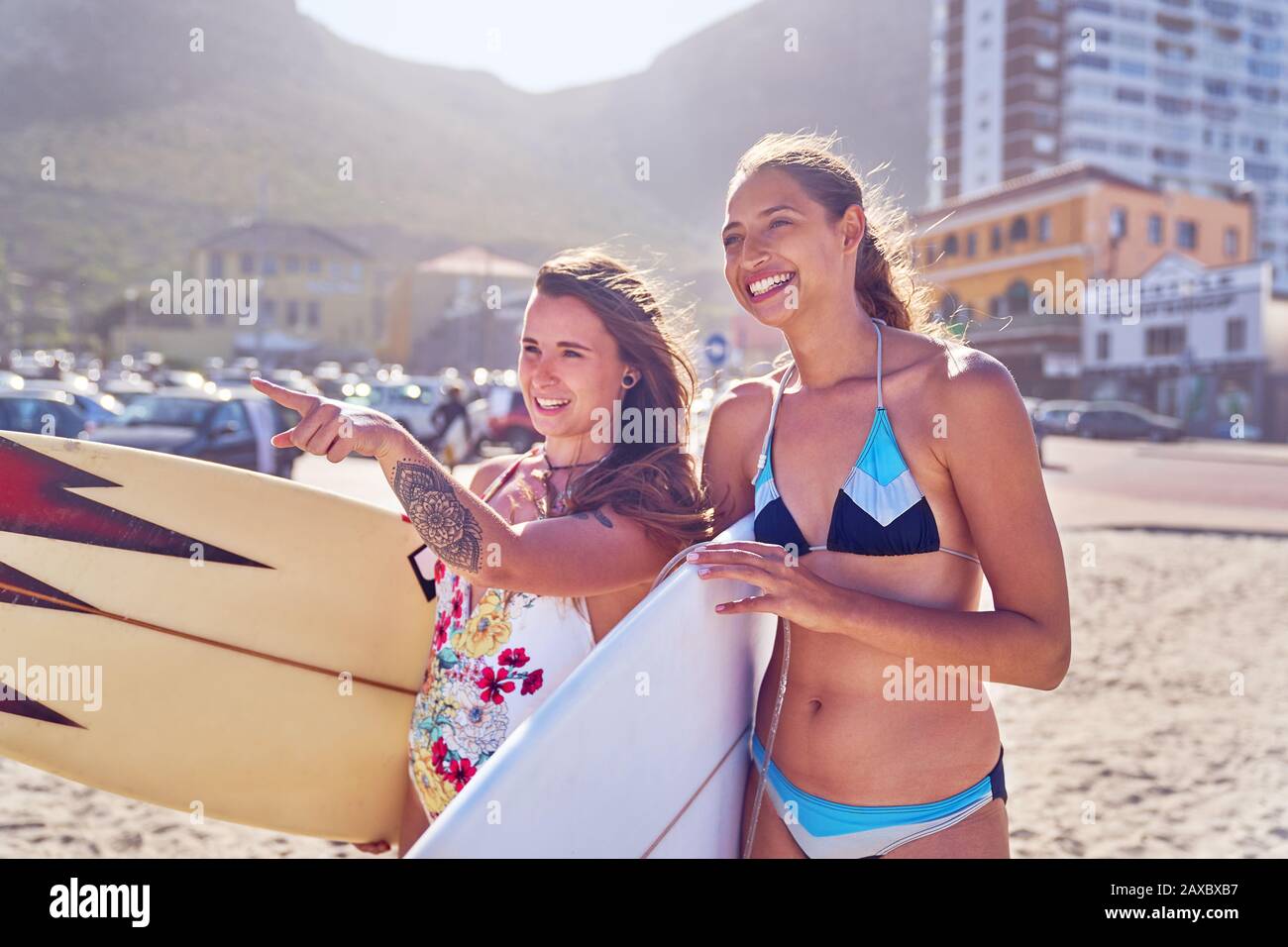 Jeunes femmes surfeuses avec planches de surf sur la plage ensoleillée Banque D'Images