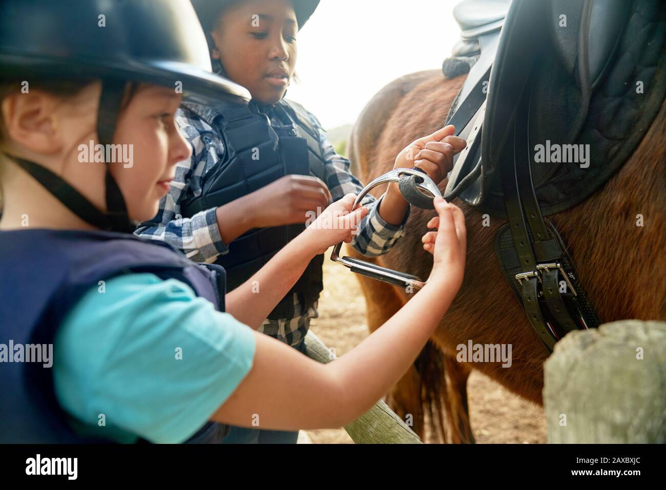 Les filles ajustent les étriers pour se préparer à l'équitation Banque D'Images