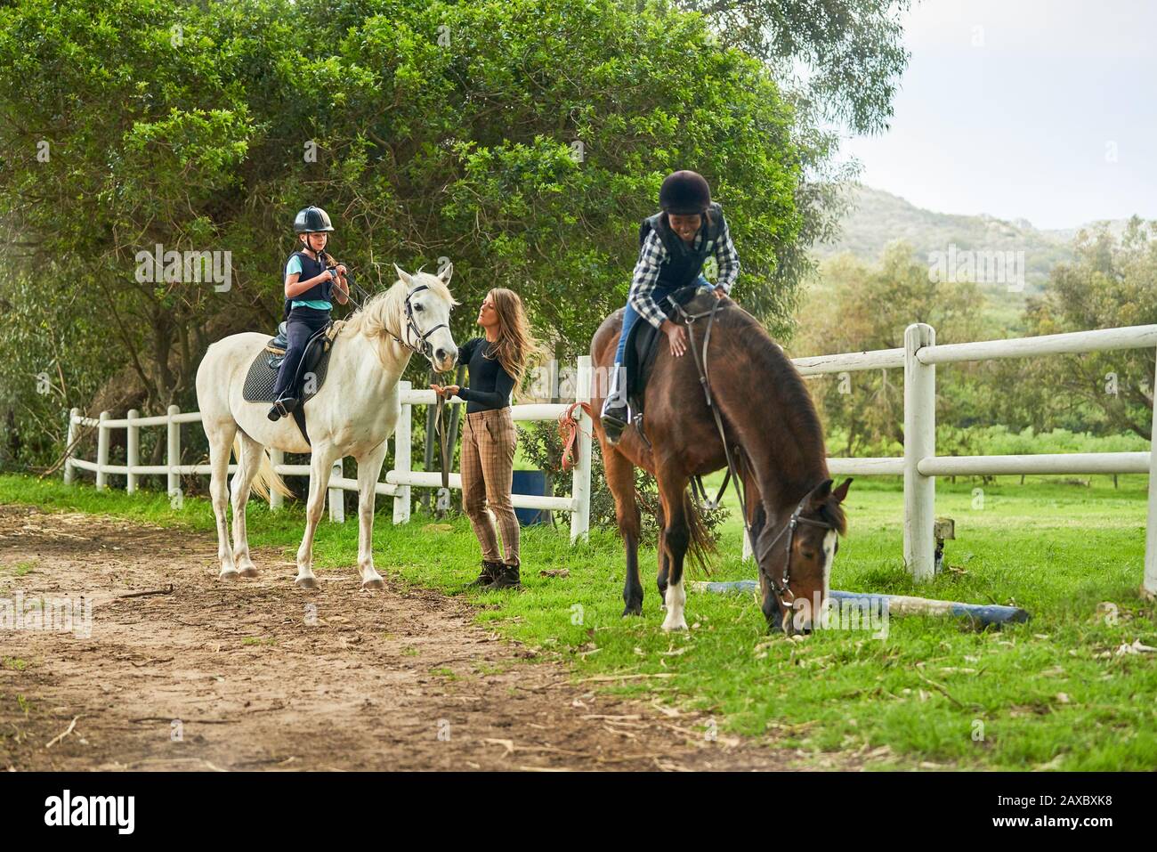 Filles se préparant à la leçon d'équitation dans le paddock rural Banque D'Images