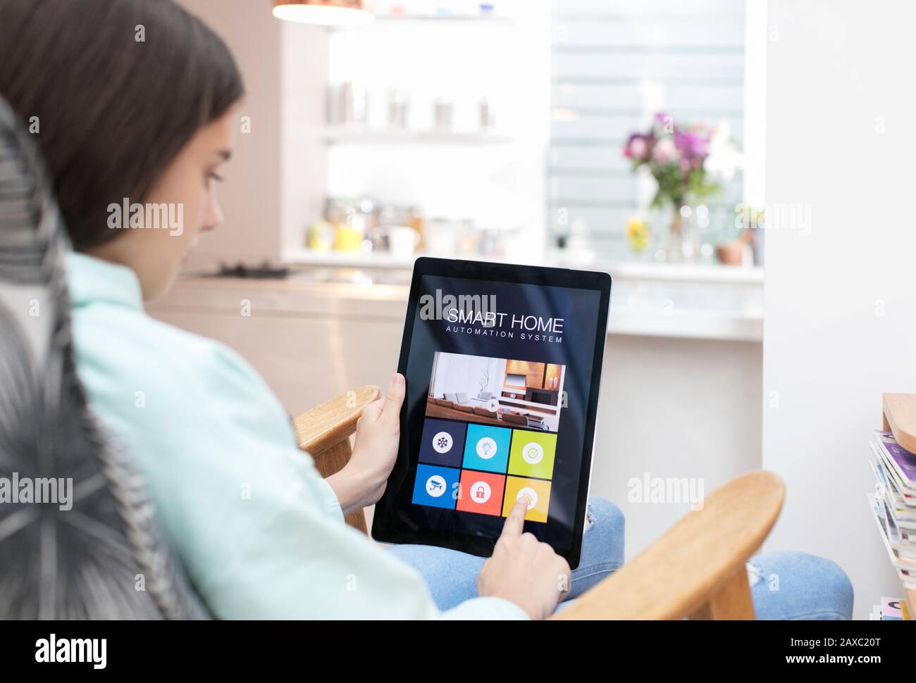 Fille utilisant un système intelligent d'automatisation domestique sur tablette numérique Banque D'Images