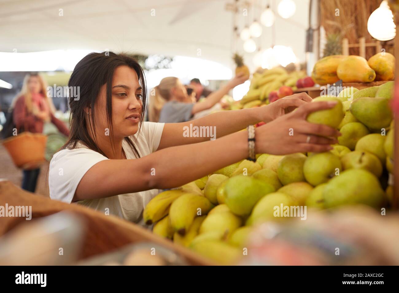 Femme travaillant, organisant des poires sur le marché des agriculteurs Banque D'Images