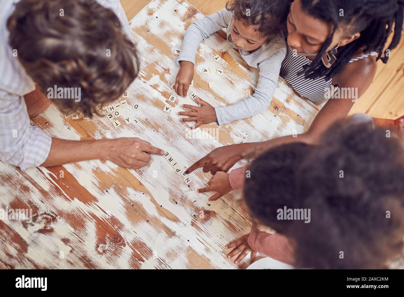 Jeune famille jouant au jeu de mots à la casse à la table Banque D'Images