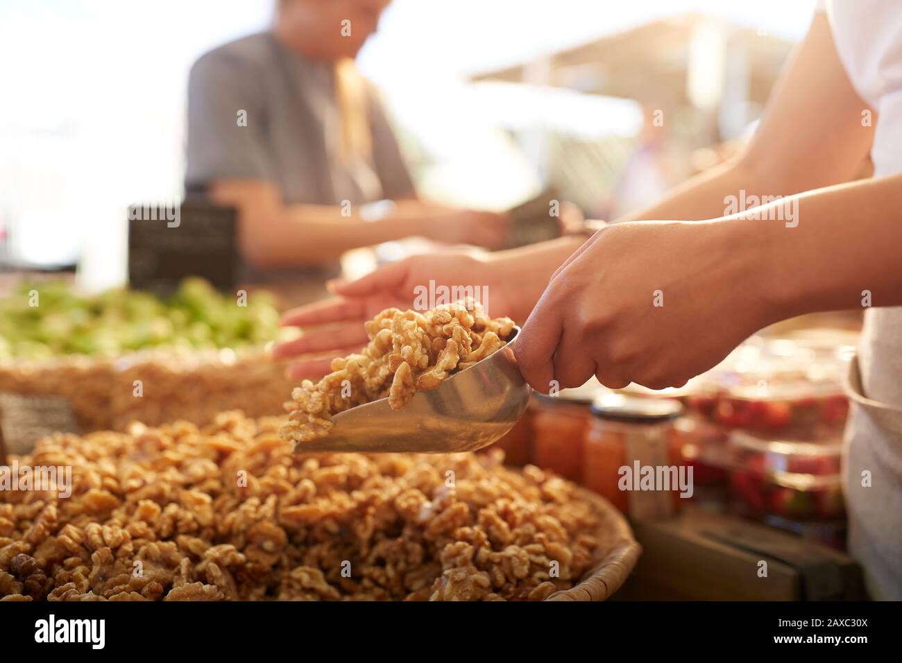 Femme ramasse des noix fraîches sur le marché des agriculteurs Banque D'Images