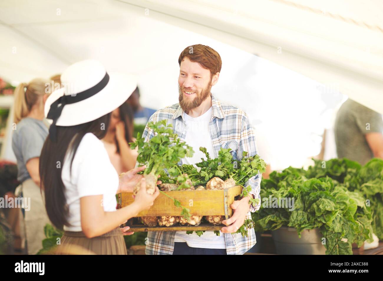 Couple avec une caisse de légumes sur le marché des agriculteurs Banque D'Images