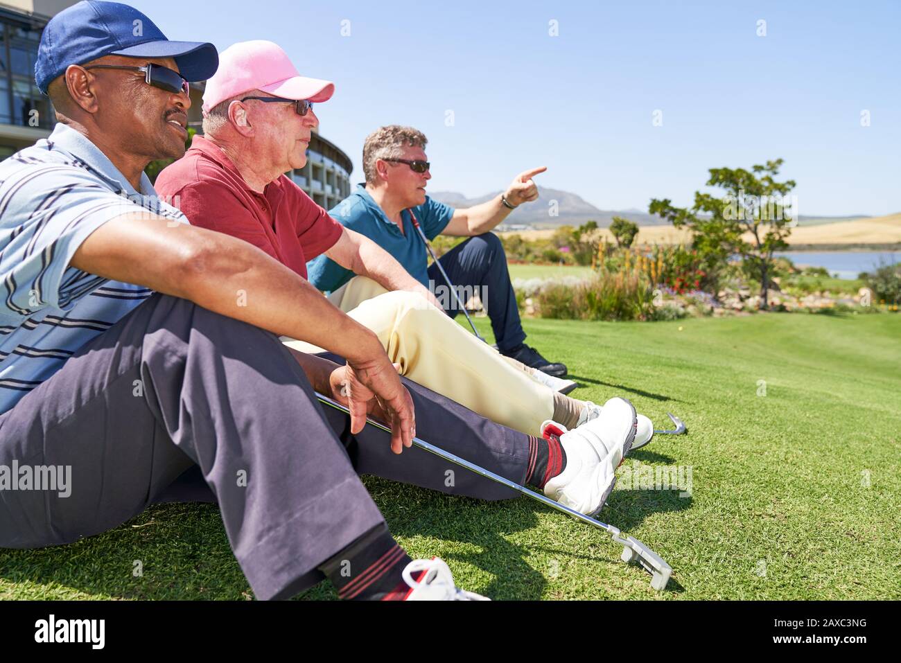 Les golfeurs de sexe masculin se reposent sur une pelouse sur un terrain de golf ensoleillé Banque D'Images