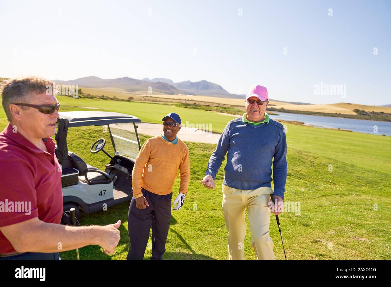 Heureux hommes d'amis de golf sur le terrain de golf ensoleillé Banque D'Images