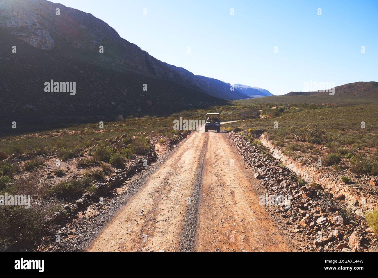 Safari véhicule tout-terrain en voiture sur route ensoleillée à distance de terre Afrique du Sud Banque D'Images