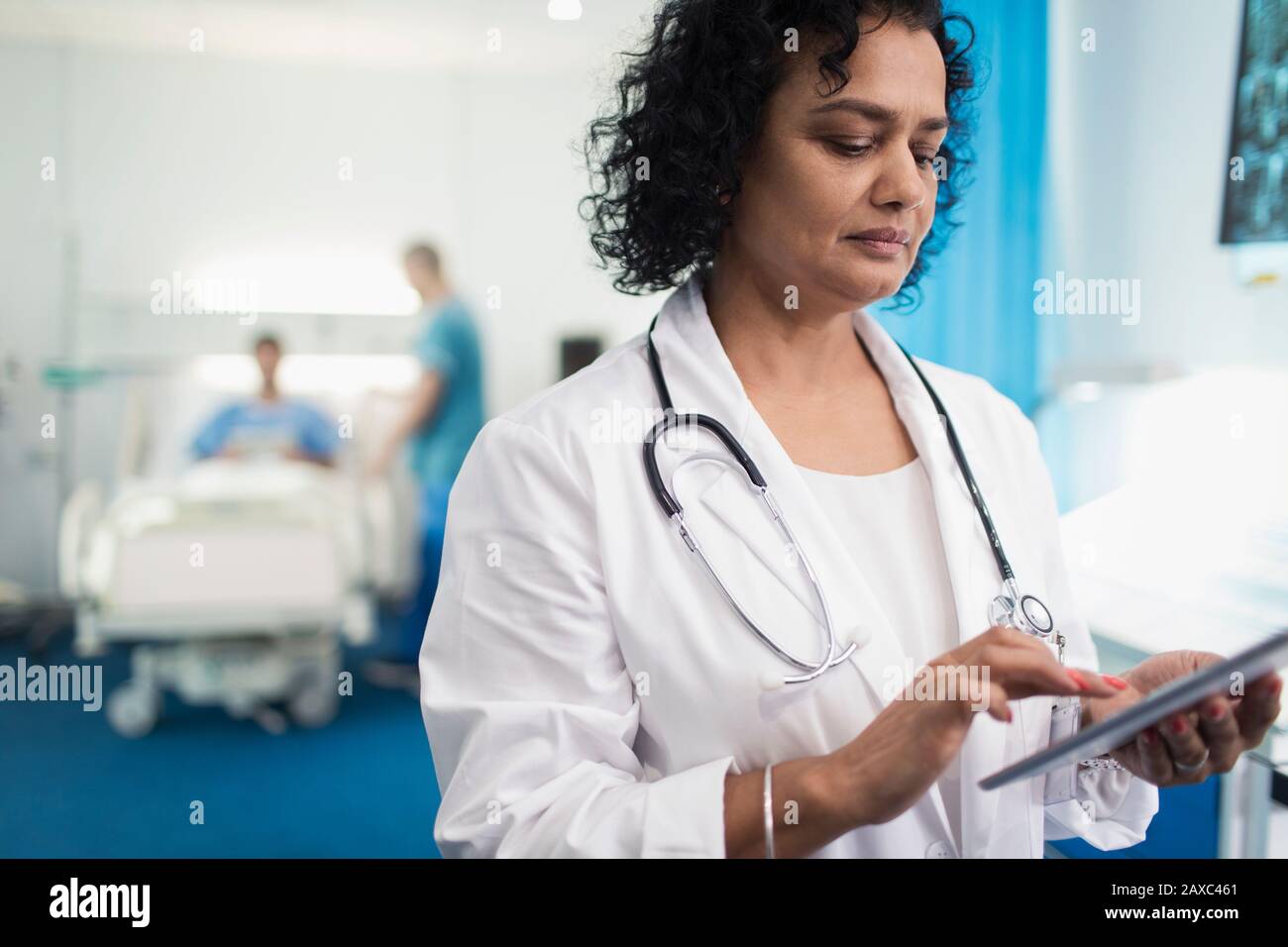 Médecin féminin utilisant une tablette numérique dans la chambre de l'hôpital Banque D'Images
