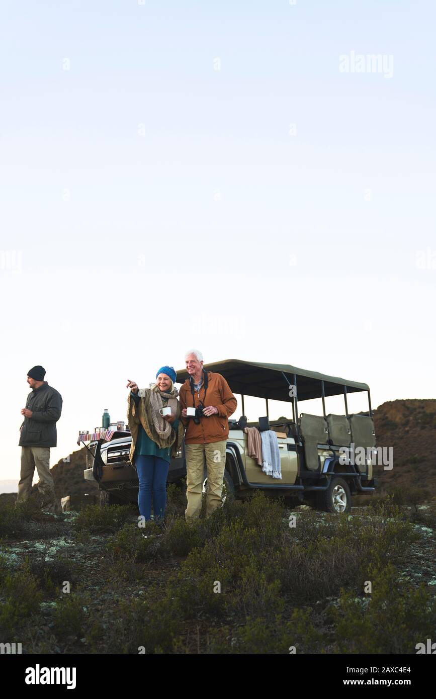 Couple senior en safari buvant du thé sur la colline Banque D'Images