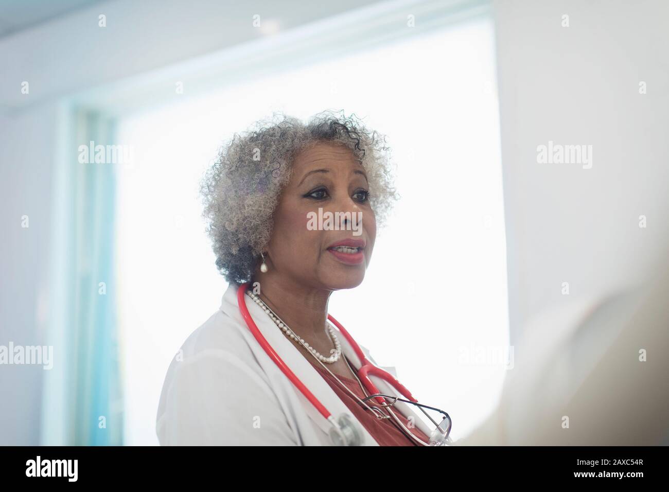 Médecin senior en train de faire des rondes, en parlant à l'hôpital Banque D'Images