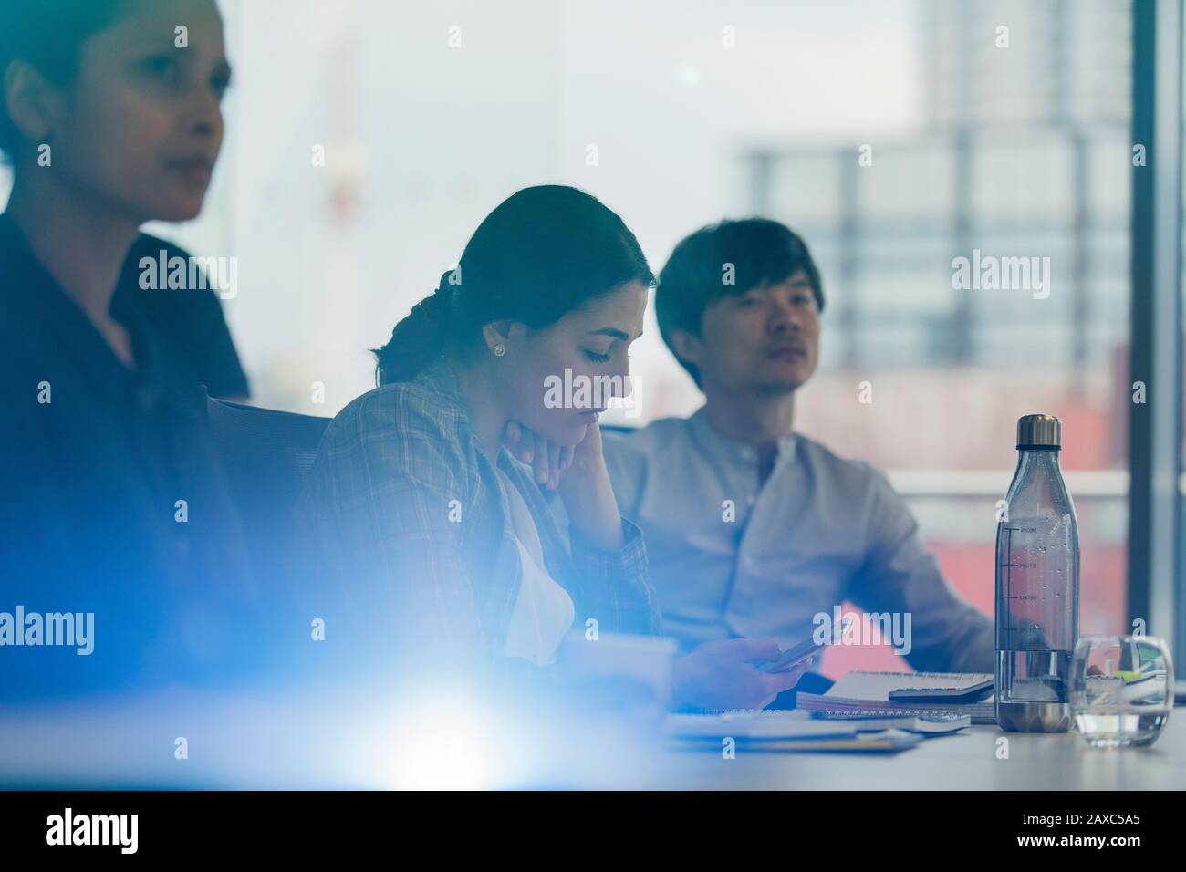 Femme d'affaires utilisant un smartphone dans la salle de conférence Banque D'Images