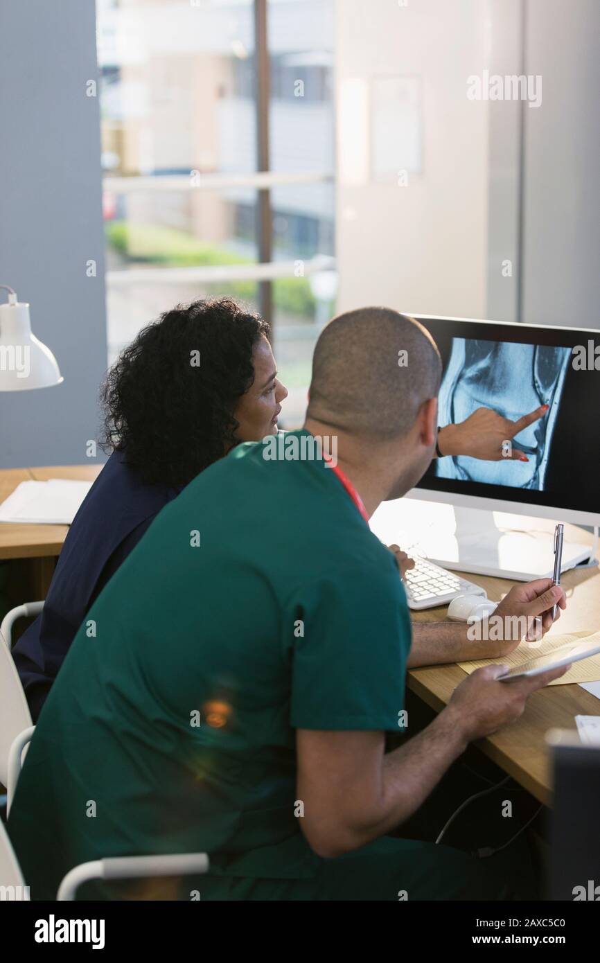 Infirmières discutant de la radiographie numérique à l'ordinateur en clinique Banque D'Images