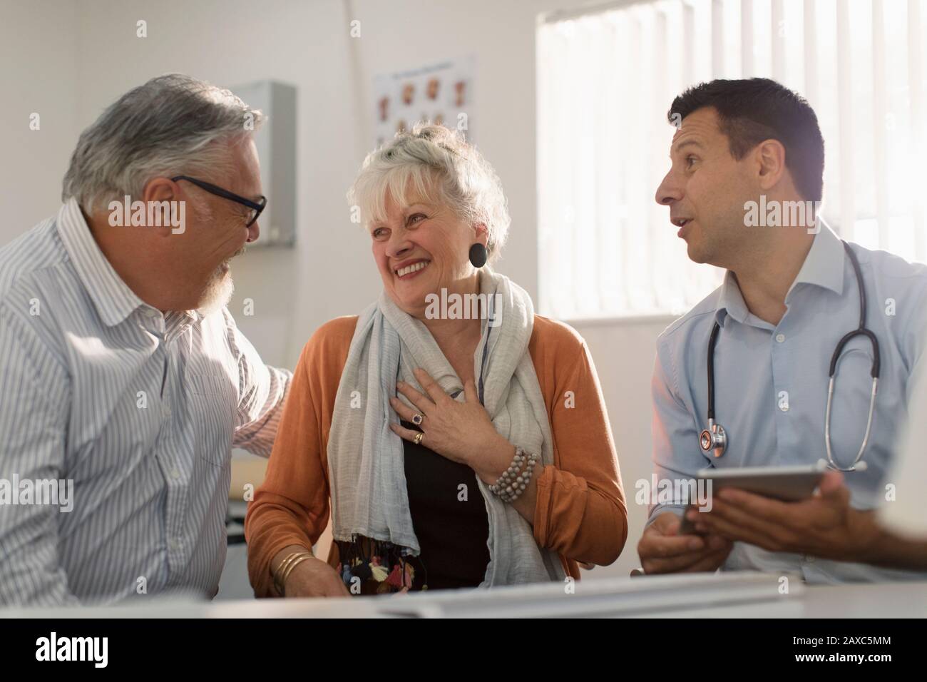 Rencontre avec un couple senior heureux dans le cabinet de médecins Banque D'Images