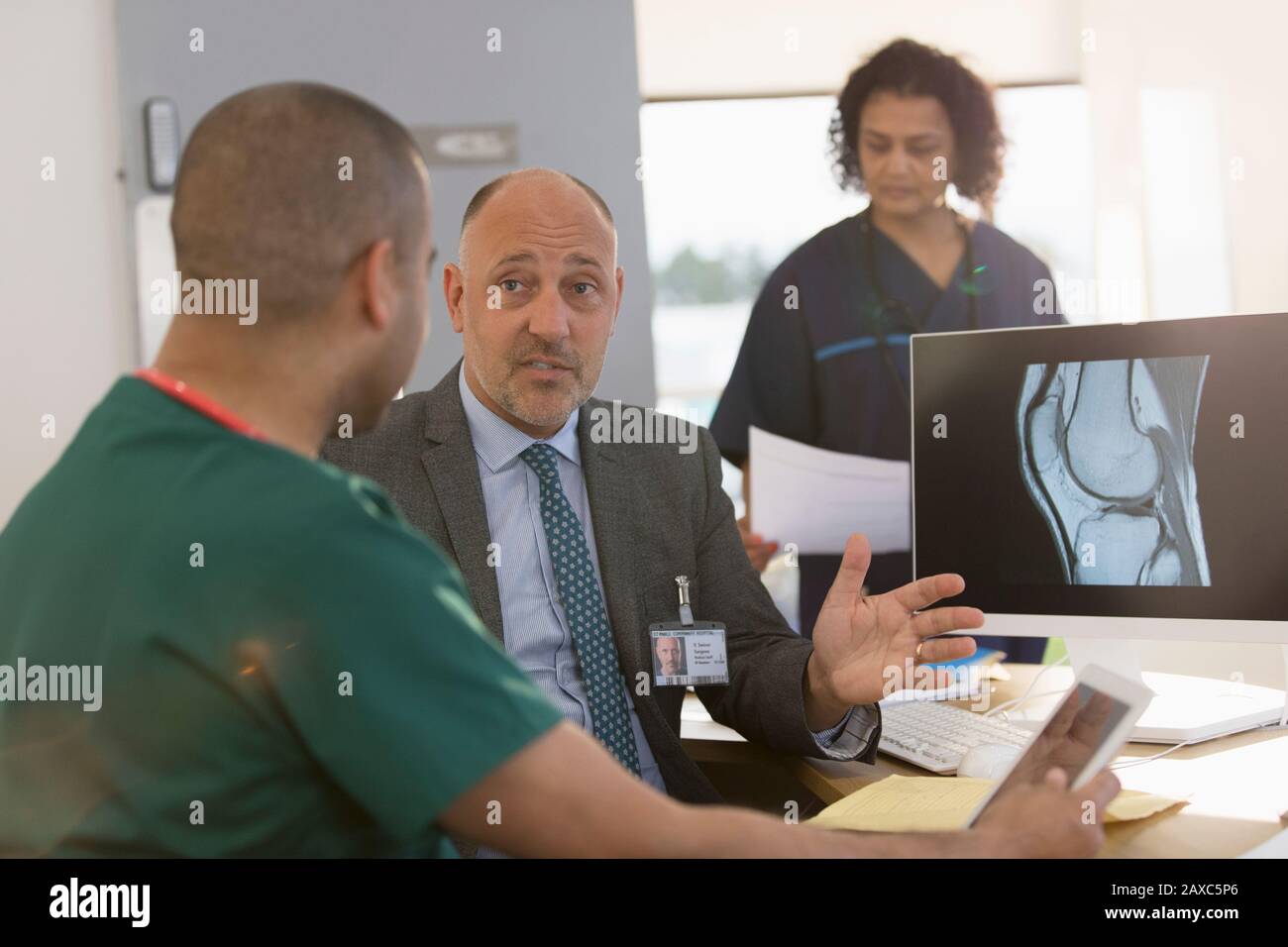 Médecin et infirmière discutant de la radiographie numérique en clinique Banque D'Images