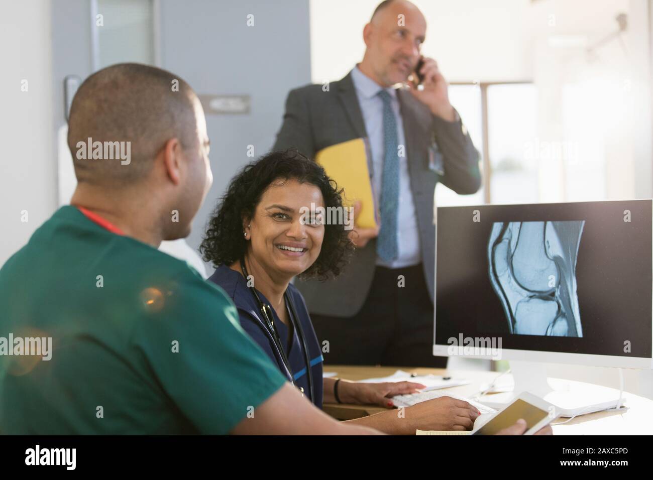 Portrait infirmière féminine confiante examinant la radiographie numérique avec un collègue en clinique Banque D'Images