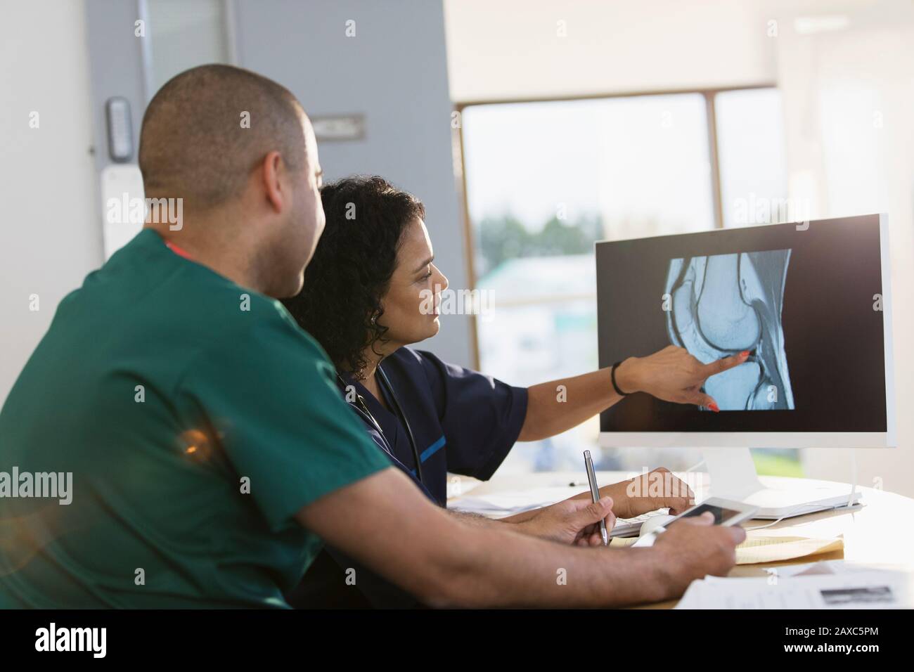 Infirmières discutant de la radiographie numérique à l'ordinateur en clinique Banque D'Images