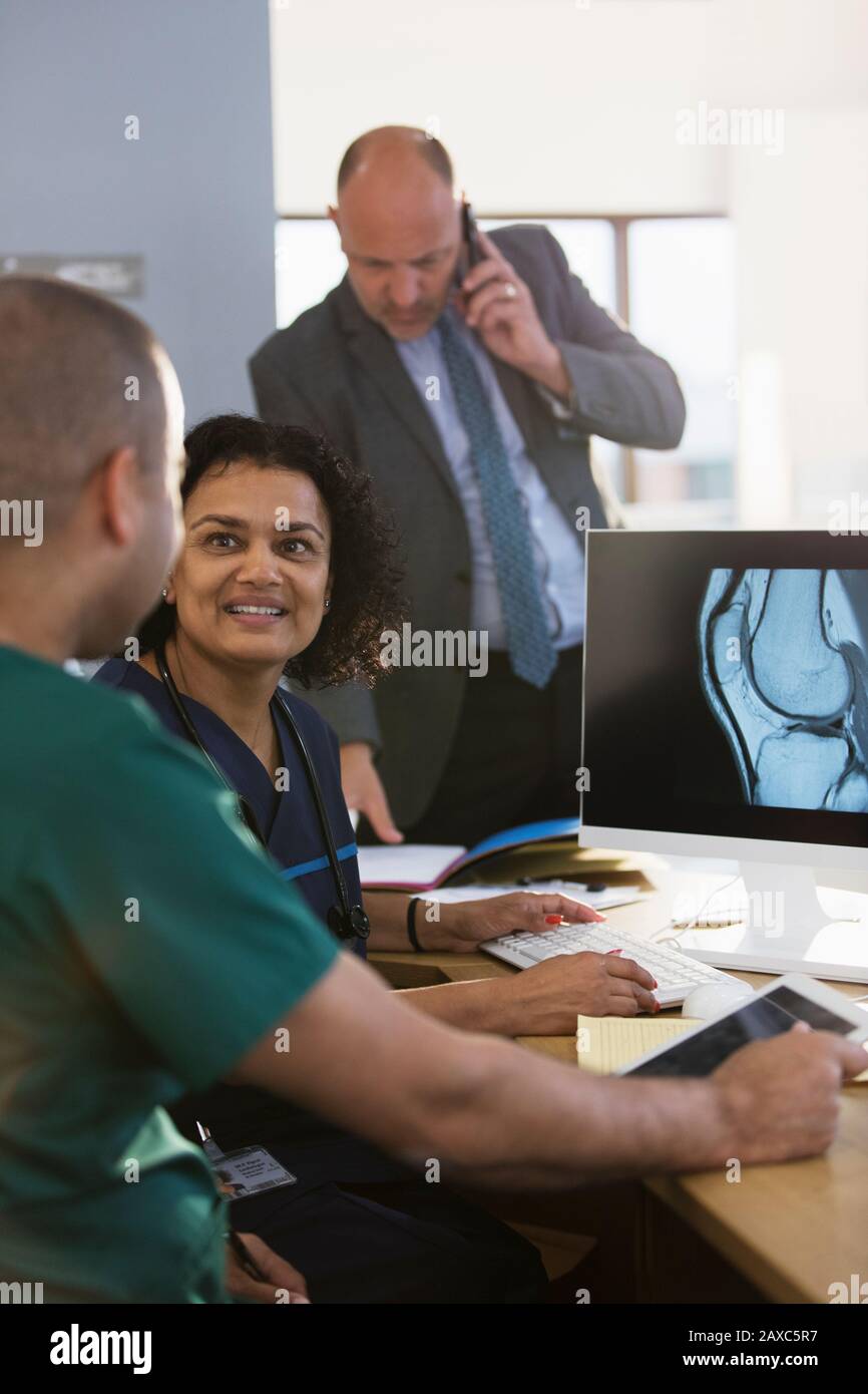 Infirmières discutant de la radiographie numérique à l'ordinateur en clinique Banque D'Images