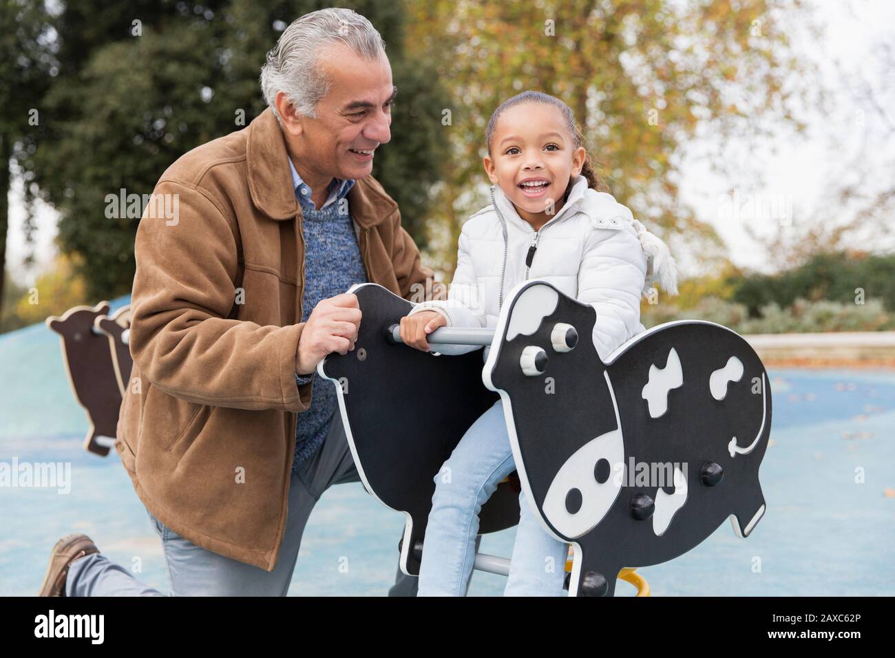 Portrait souriant grand-père et petite-fille jouant à l'aire de jeux Banque D'Images