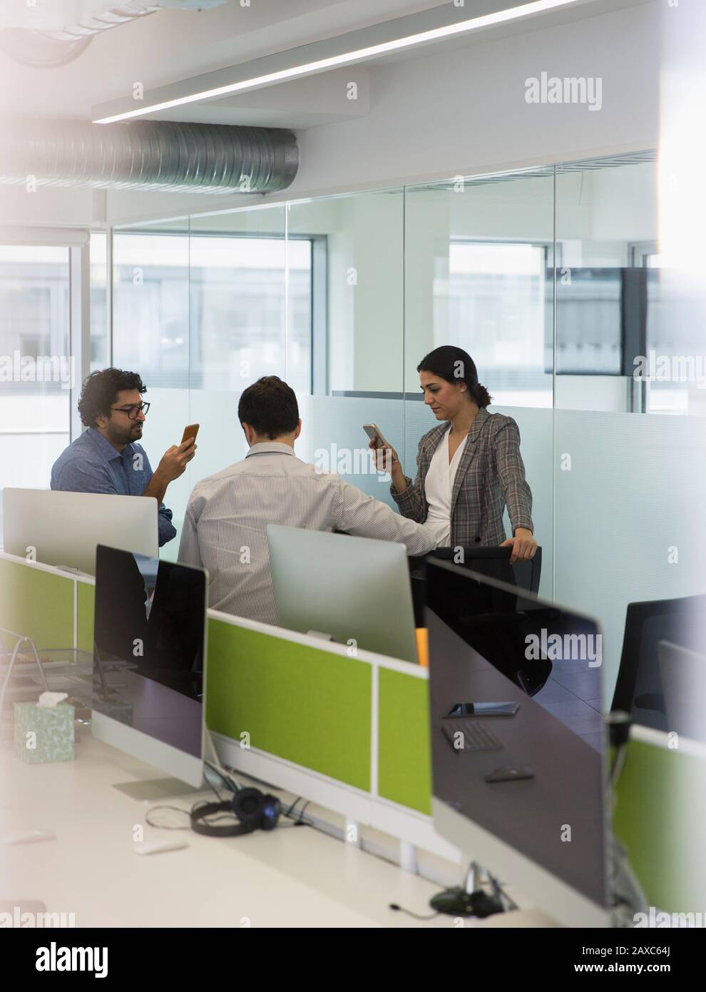 Les gens d'affaires avec smartphones se rencontrent dans un bureau en plan ouvert Banque D'Images