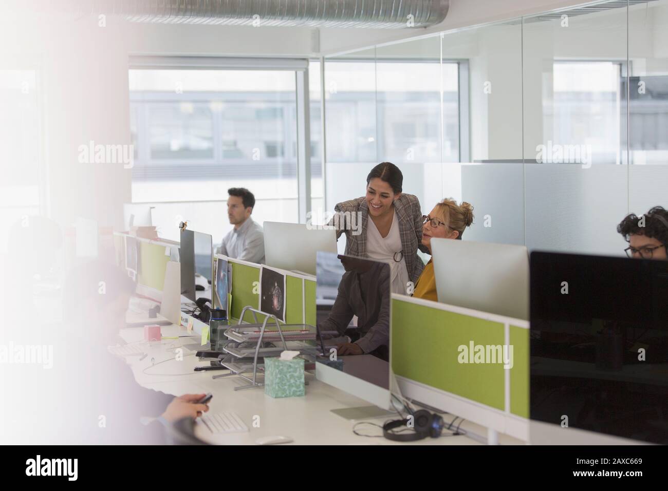 Les femmes d'affaires parlent, se rencontrent à l'ordinateur dans un bureau en plan ouvert Banque D'Images