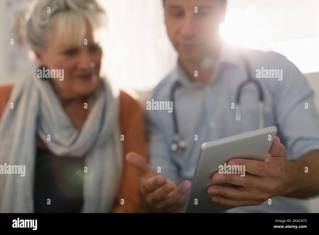 Médecin homme montrant une tablette numérique au patient Banque D'Images