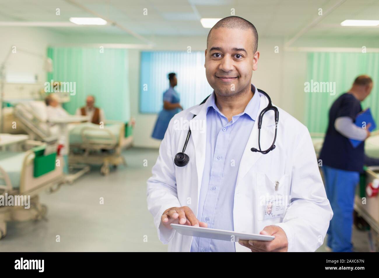 Portrait confiant médecin de faire des rondes, à l'aide d'une tablette numérique dans le service hospitalier Banque D'Images