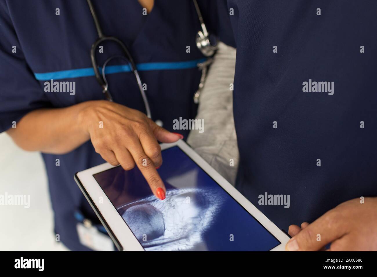 Gros plan sur les médecins qui examinent la radiographie numérique sur une tablette numérique à l'hôpital Banque D'Images