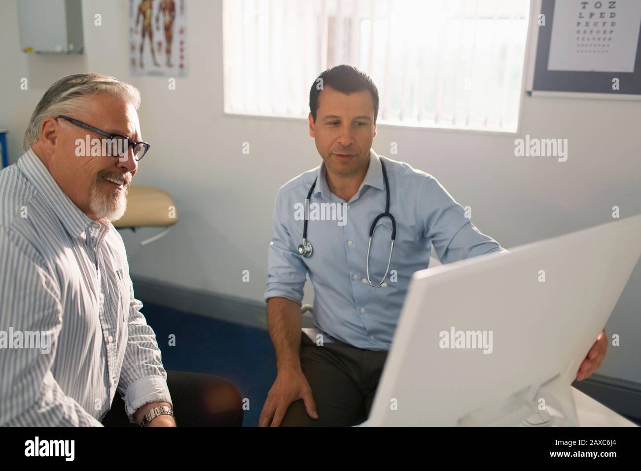 Rencontre avec un médecin de sexe masculin avec un patient senior dans un bureau de médecins Banque D'Images