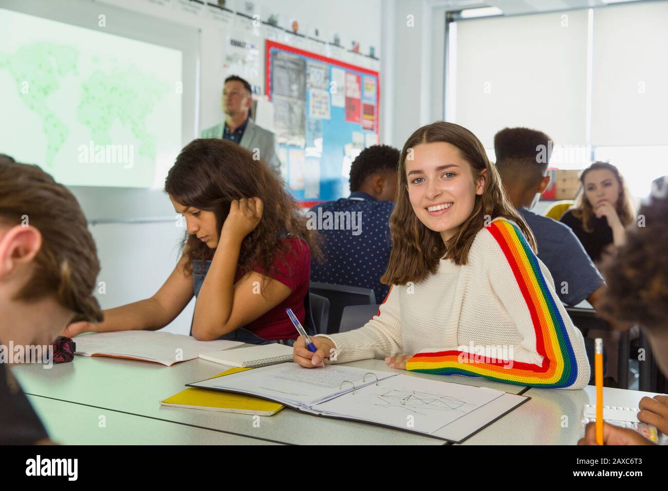 Portrait confiant jeune fille de lycée prenant des notes pendant la leçon de géographie en classe Banque D'Images