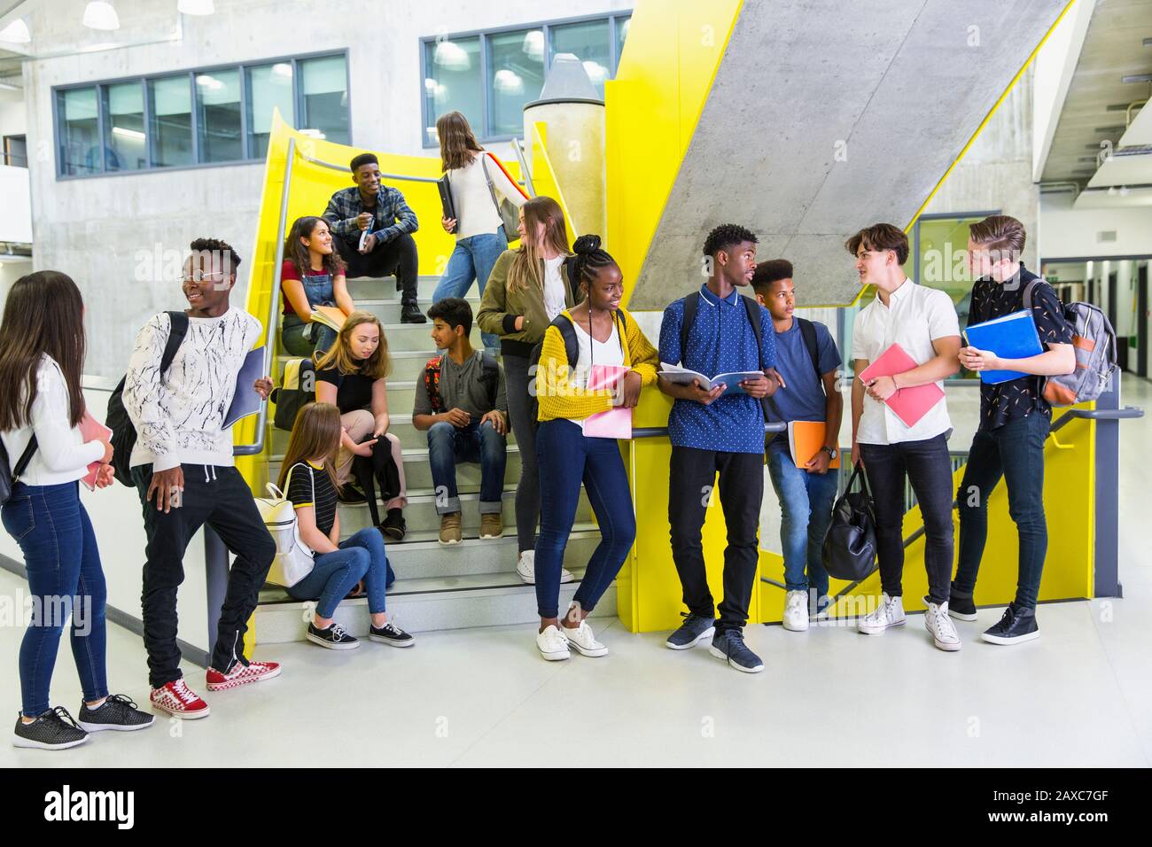 Les étudiants juniors penchant dans les escaliers Banque D'Images