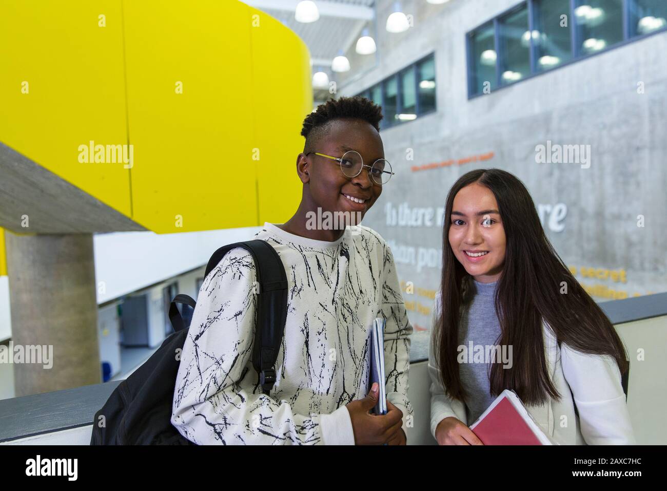 Portrait confiant étudiants juniors haut dans le couloir Banque D'Images