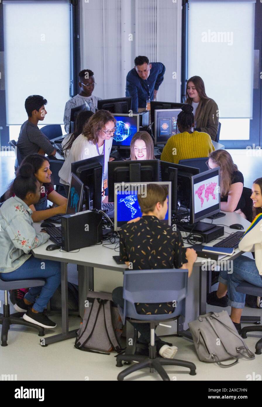 Jeunes étudiants et enseignants utilisant des ordinateurs en laboratoire informatique Banque D'Images