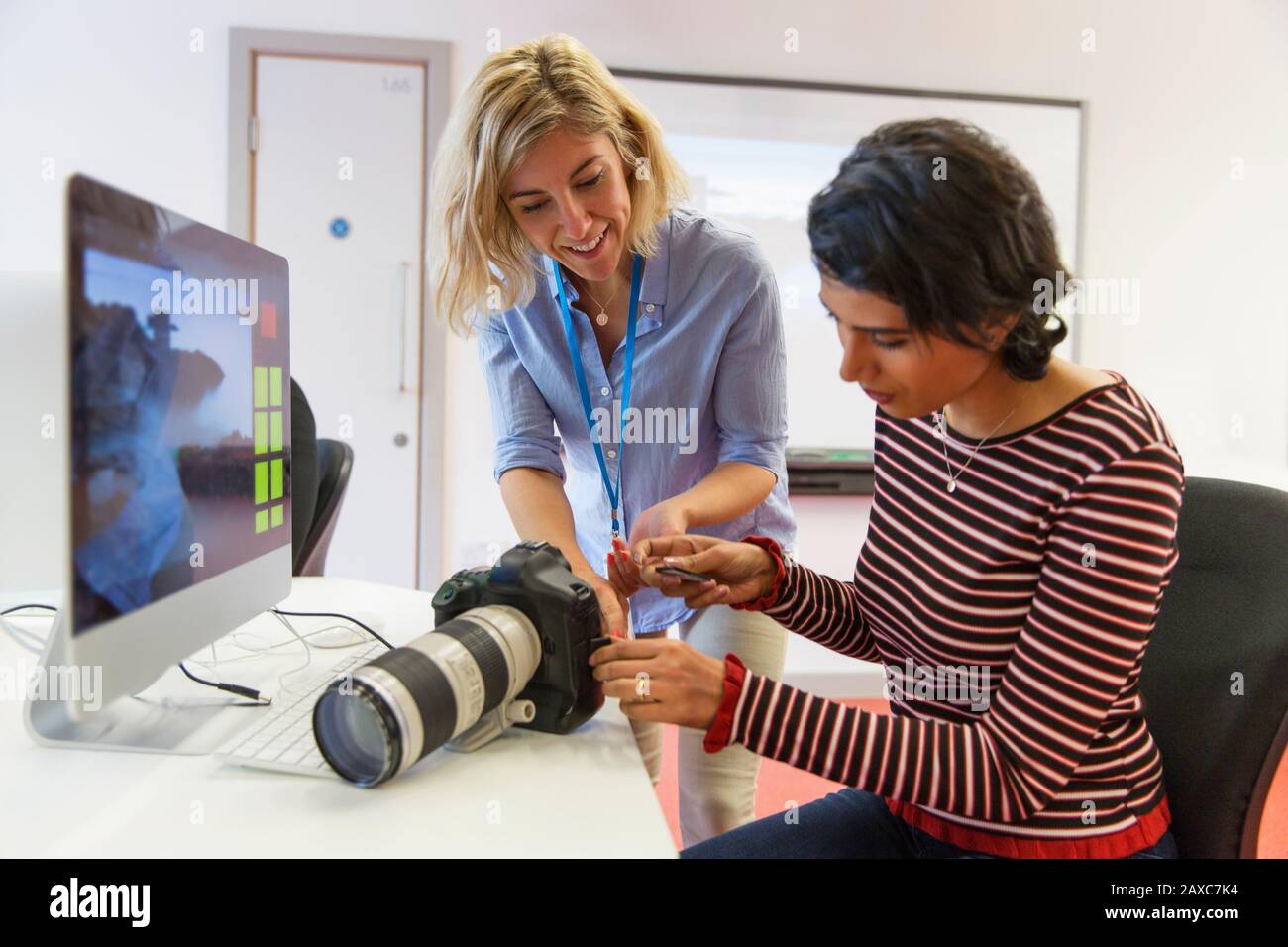 Photographe féminin enseignant aux étudiants comment utiliser l'appareil photo SLR Banque D'Images