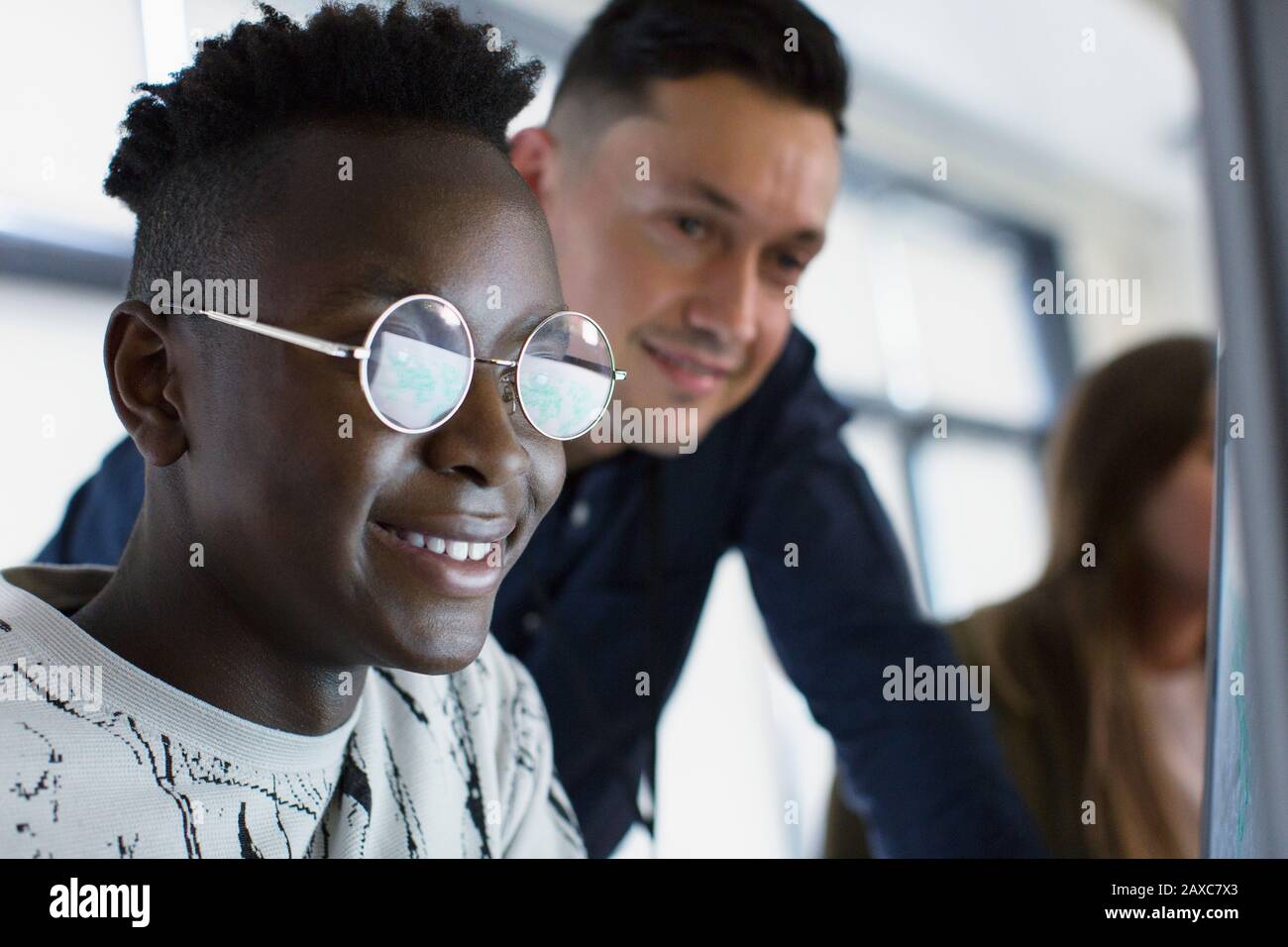 Enseignant secondaire aidant l'étudiant garçon à l'ordinateur Banque D'Images