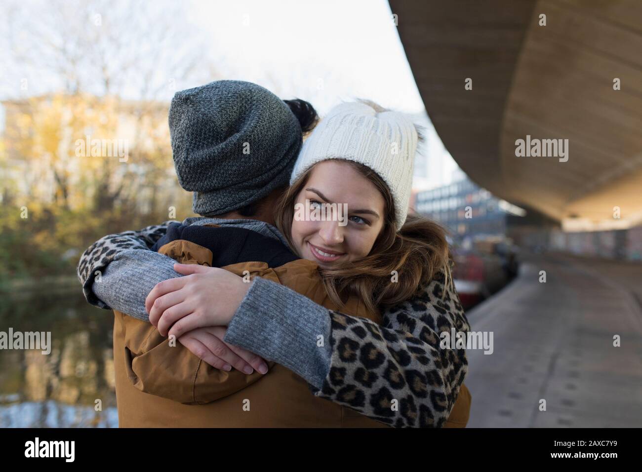 Un jeune couple heureux s'embrassant le long du canal urbain Banque D'Images