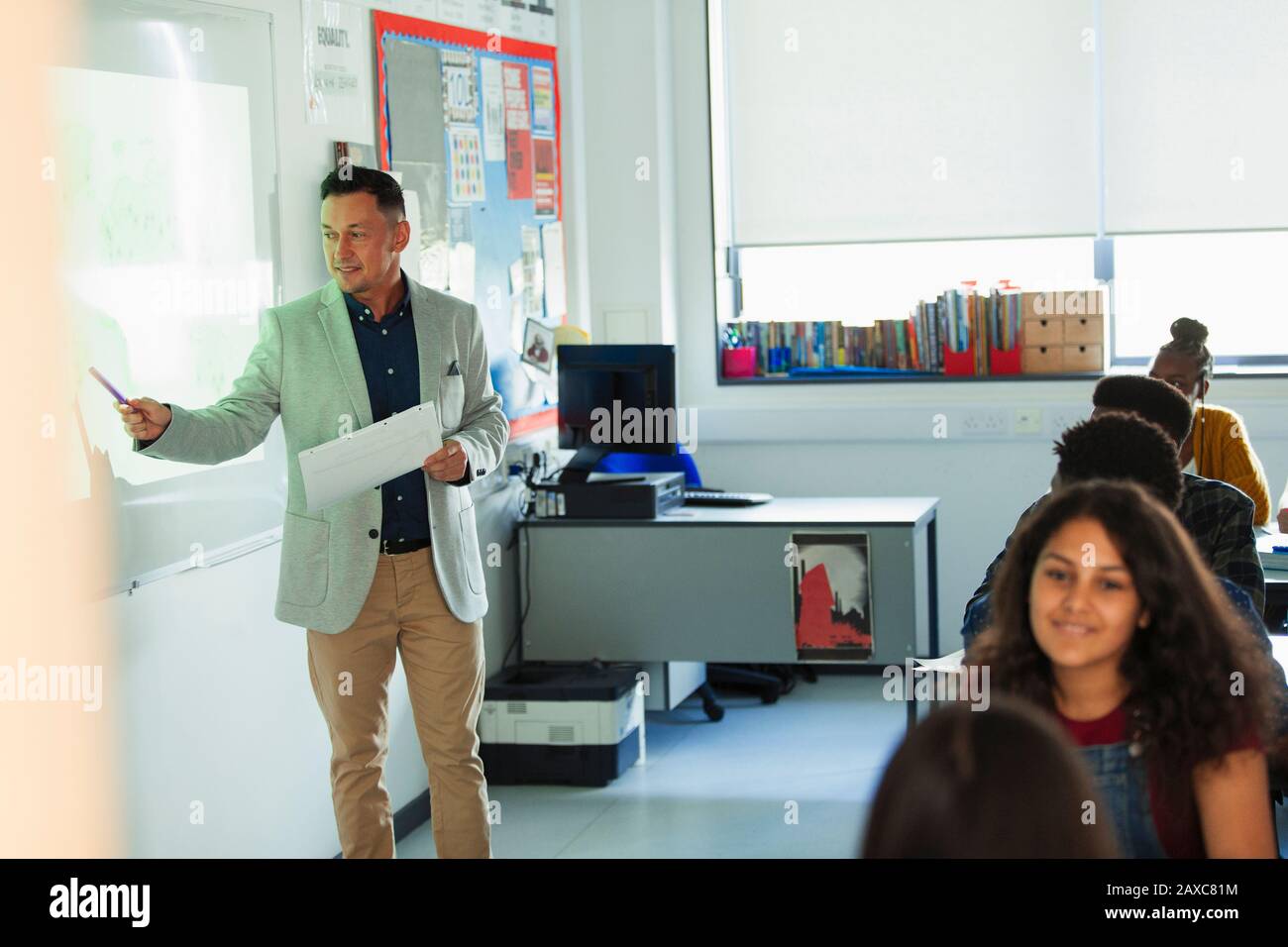 Professeur d'école secondaire masculin de la leçon de tête à l'écran de projection en salle de classe Banque D'Images